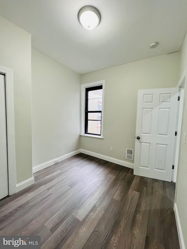 spare room with dark hardwood / wood-style flooring