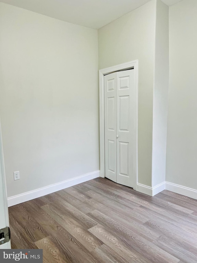 unfurnished bedroom featuring light wood-type flooring and a closet