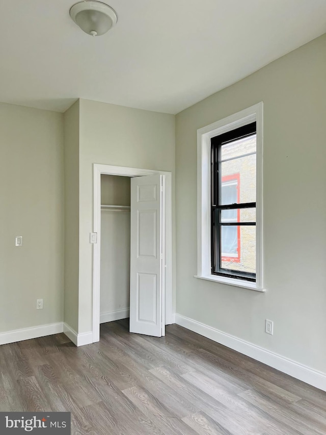 unfurnished bedroom with a closet and light hardwood / wood-style floors