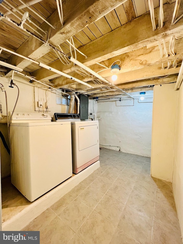 basement with electric panel and washer and clothes dryer