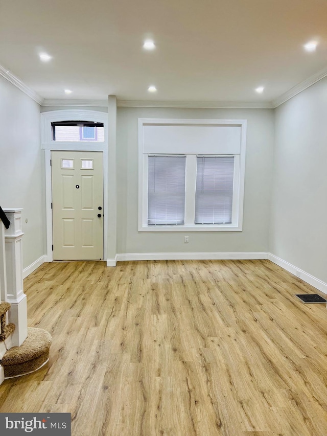 entryway with light wood-type flooring and ornamental molding