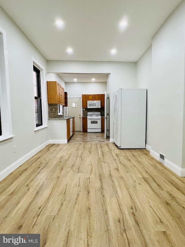 unfurnished living room with light hardwood / wood-style flooring and sink