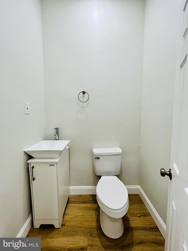 bathroom with vanity, toilet, and hardwood / wood-style floors