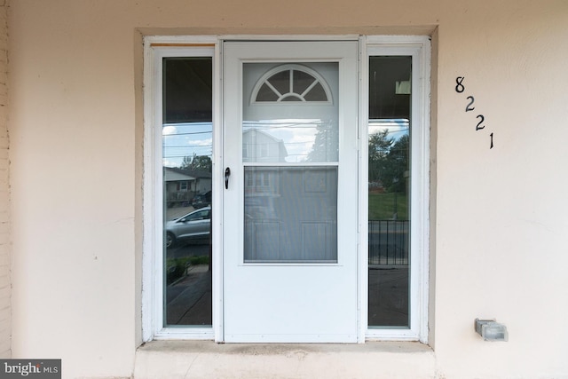 entrance to property featuring stucco siding