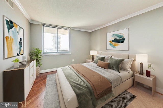 bedroom with a textured ceiling, ornamental molding, and hardwood / wood-style flooring