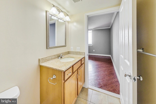 bathroom featuring ornamental molding, vanity, toilet, and hardwood / wood-style flooring