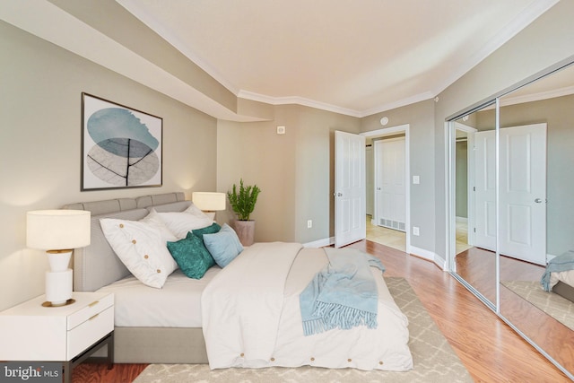 bedroom featuring ornamental molding, a closet, and hardwood / wood-style flooring