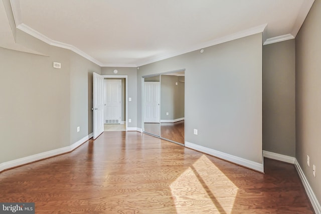 unfurnished room with ornamental molding and wood-type flooring