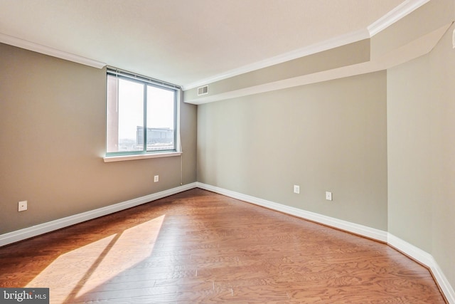 unfurnished room with hardwood / wood-style flooring and crown molding