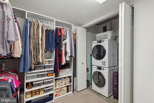 clothes washing area featuring stacked washer and clothes dryer and light colored carpet