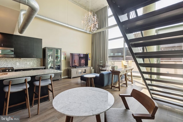 dining space with a high ceiling, dark hardwood / wood-style flooring, and a chandelier