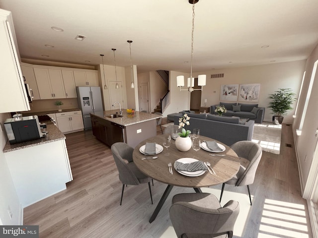 dining room featuring sink and light hardwood / wood-style flooring