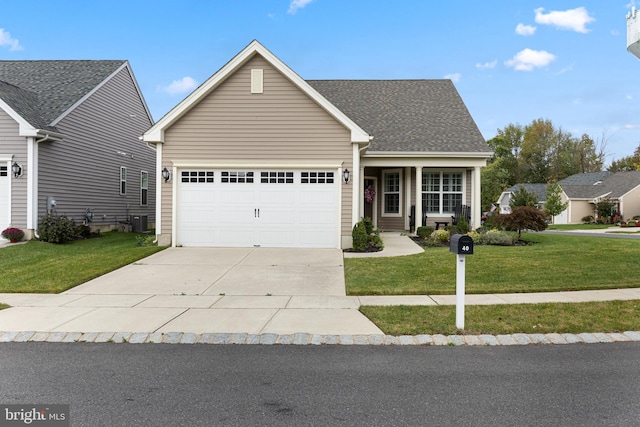 view of front of property with a front yard, central air condition unit, and a garage