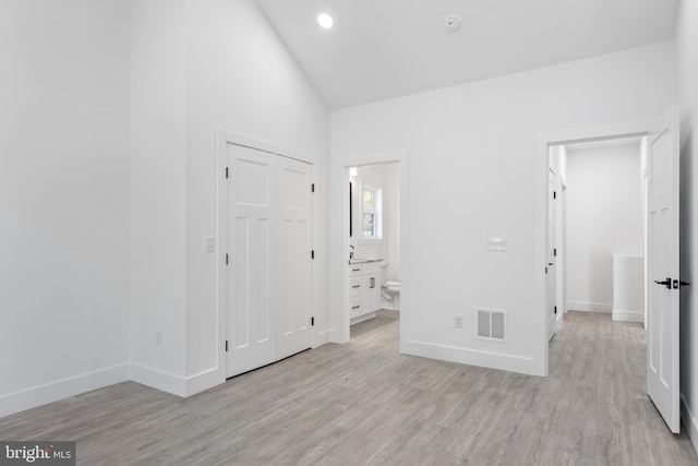 interior space with light hardwood / wood-style flooring and high vaulted ceiling