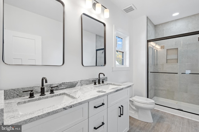 bathroom with vanity, toilet, hardwood / wood-style flooring, and an enclosed shower