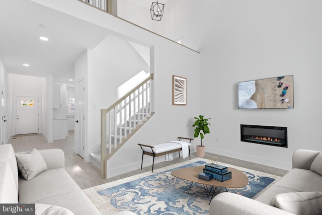 living room with light hardwood / wood-style flooring and a high ceiling