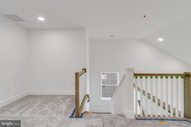 staircase with lofted ceiling and carpet