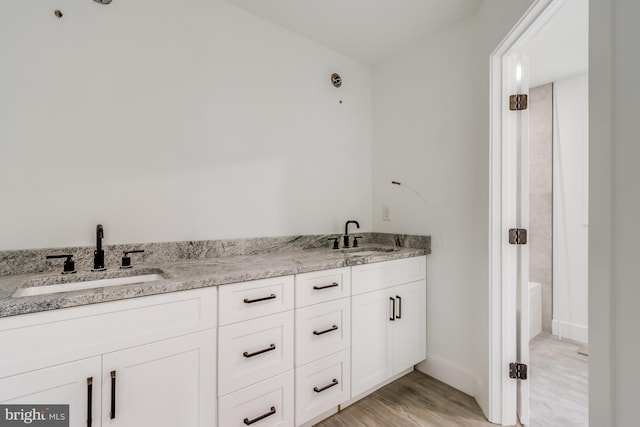 bathroom featuring vanity, hardwood / wood-style floors, and a bathing tub