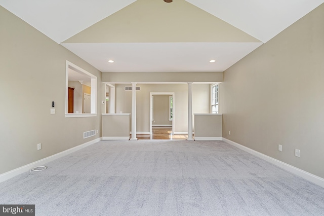 unfurnished living room featuring light colored carpet and decorative columns