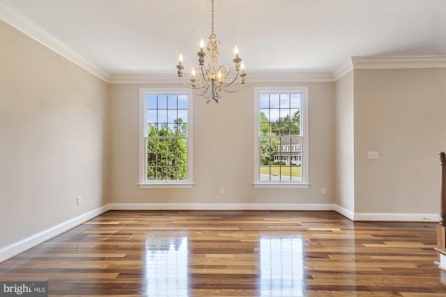 unfurnished room with an inviting chandelier, crown molding, and hardwood / wood-style floors