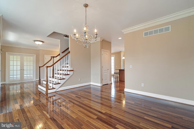 unfurnished room with french doors, ornamental molding, dark hardwood / wood-style floors, and a chandelier