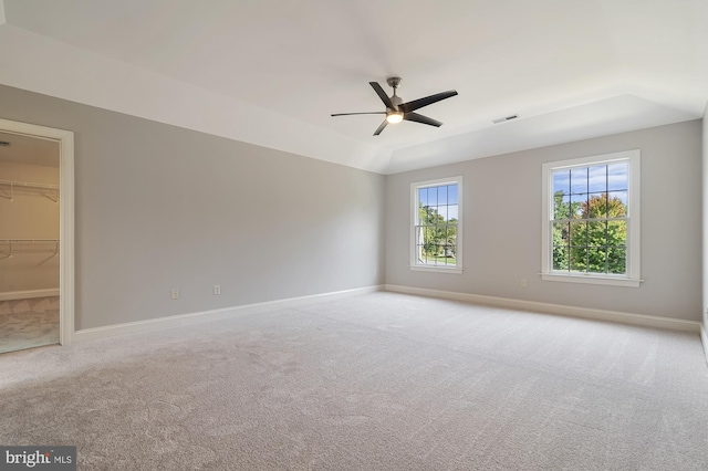 spare room with ceiling fan, light colored carpet, and vaulted ceiling