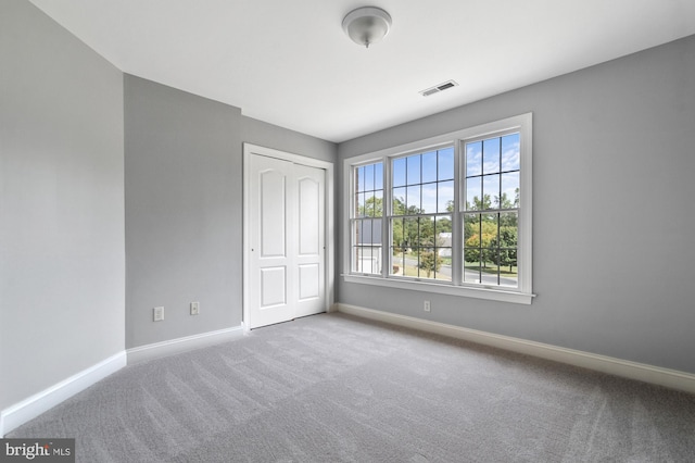 interior space with light carpet and a closet