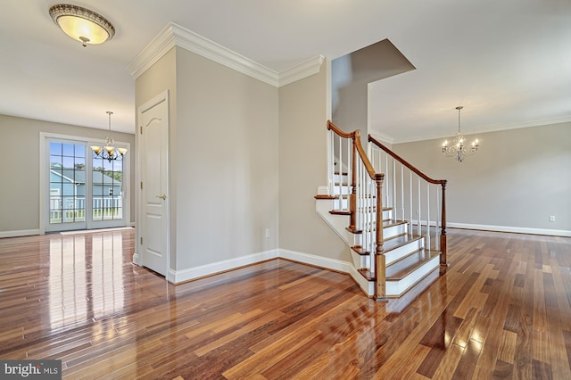 stairway with an inviting chandelier, hardwood / wood-style flooring, and crown molding