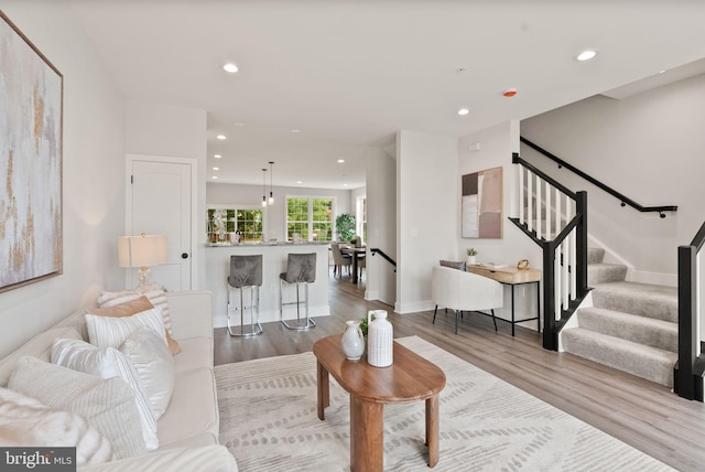 living area featuring stairway, recessed lighting, wood finished floors, and baseboards