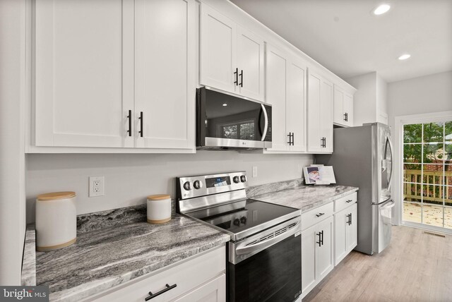 kitchen featuring appliances with stainless steel finishes, light hardwood / wood-style floors, light stone countertops, and white cabinets