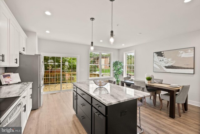 kitchen featuring pendant lighting, a center island, light hardwood / wood-style floors, and white cabinetry