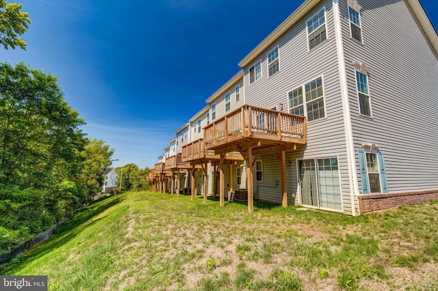 rear view of property featuring a deck, a yard, and central air condition unit