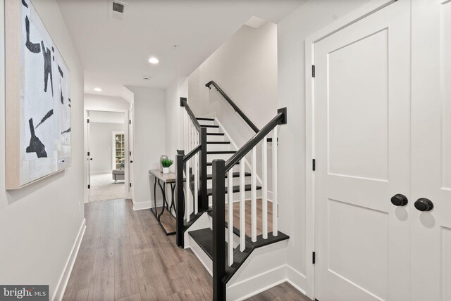 hall featuring visible vents, baseboards, stairway, recessed lighting, and wood finished floors