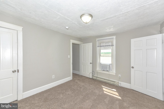 unfurnished bedroom featuring carpet floors, cooling unit, a textured ceiling, and a baseboard heating unit