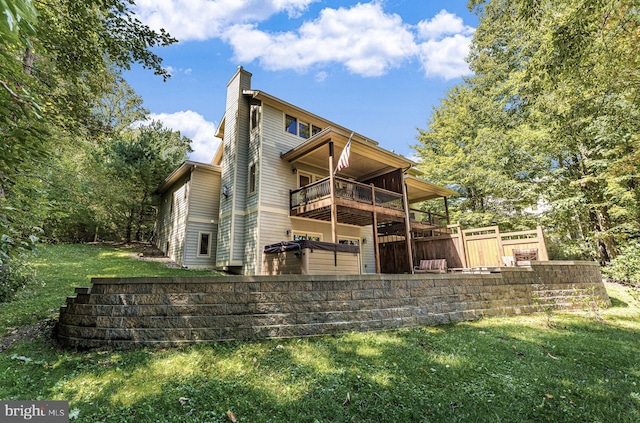 back of house with a balcony and a yard