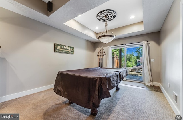 rec room with a tray ceiling, billiards, and carpet floors