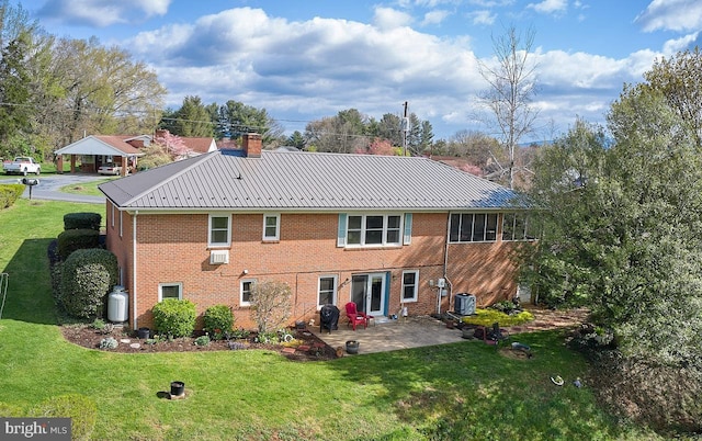 back of house with central AC unit, a yard, and a patio