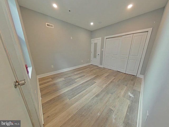 unfurnished bedroom with a closet and light hardwood / wood-style floors