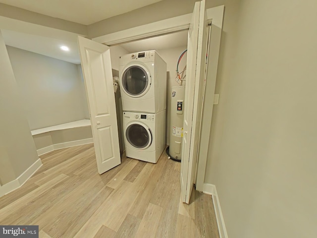 laundry area featuring electric water heater, light hardwood / wood-style flooring, and stacked washer and clothes dryer