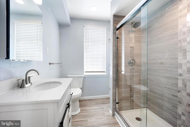 bathroom with vanity, toilet, hardwood / wood-style floors, and an enclosed shower