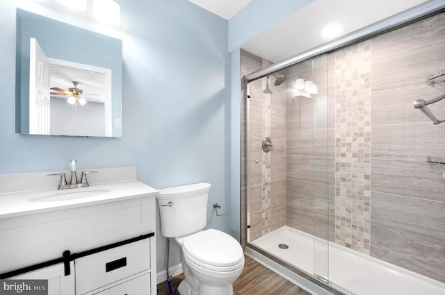 bathroom featuring toilet, walk in shower, vanity, ceiling fan, and hardwood / wood-style flooring