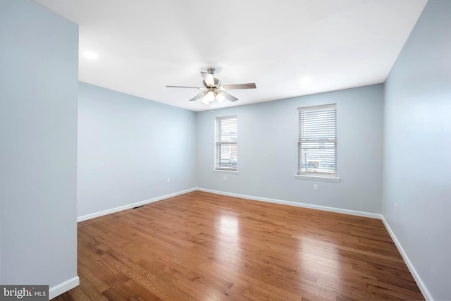 empty room with ceiling fan and light hardwood / wood-style floors