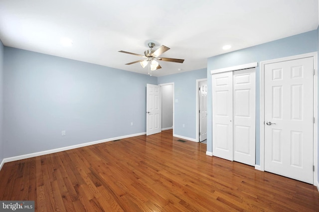 unfurnished bedroom with ceiling fan and wood-type flooring