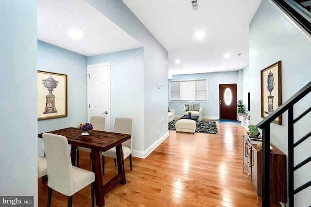 entryway with visible vents, stairway, light wood-type flooring, and baseboards