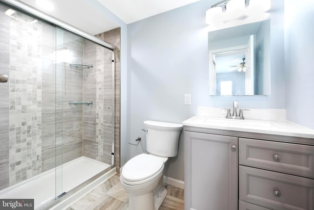 bathroom with an enclosed shower, ceiling fan, toilet, and vanity