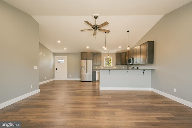 kitchen featuring kitchen peninsula, stainless steel appliances, ceiling fan, hardwood / wood-style flooring, and lofted ceiling