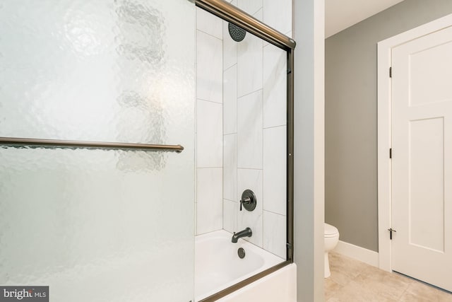 bathroom featuring tile patterned floors, toilet, and enclosed tub / shower combo