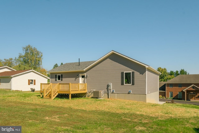 rear view of property with a yard, central AC unit, and a deck