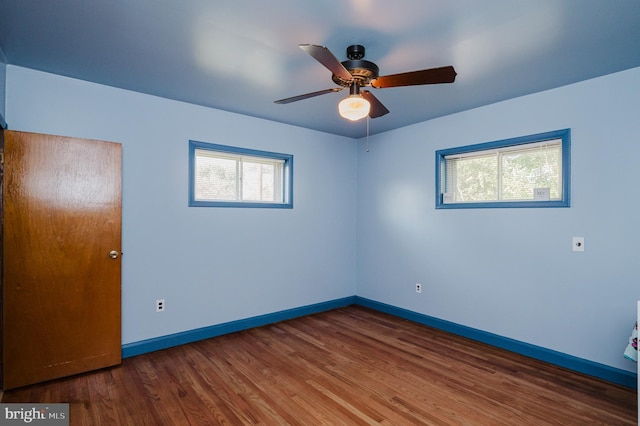 empty room with ceiling fan and dark hardwood / wood-style flooring