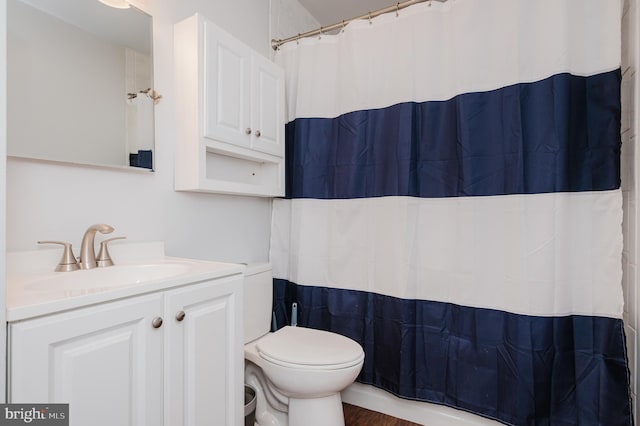 bathroom featuring a shower with curtain, vanity, hardwood / wood-style flooring, and toilet